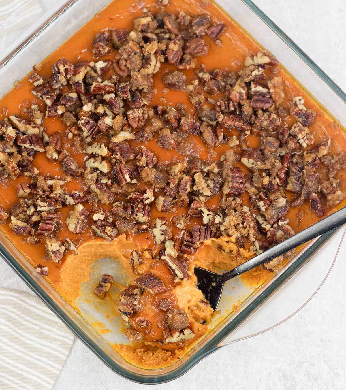 Pumpkin Custard topped with pecans in a baking pan
