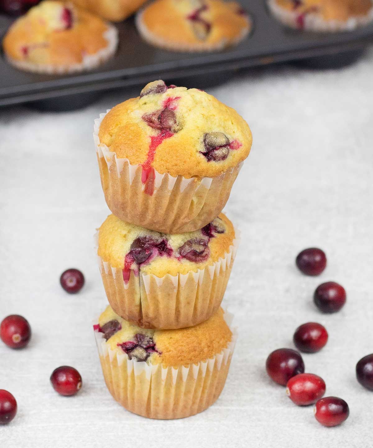 Cranberry Muffins on top of each others and some fresh Cranberries around