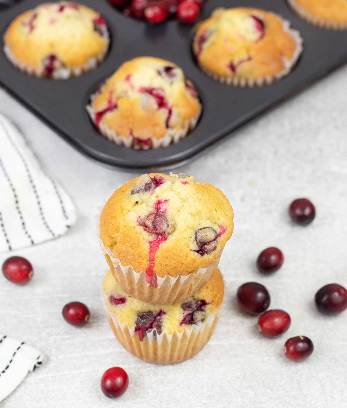 Cranberry Muffins on top of each others and some fresh Cranberries around
