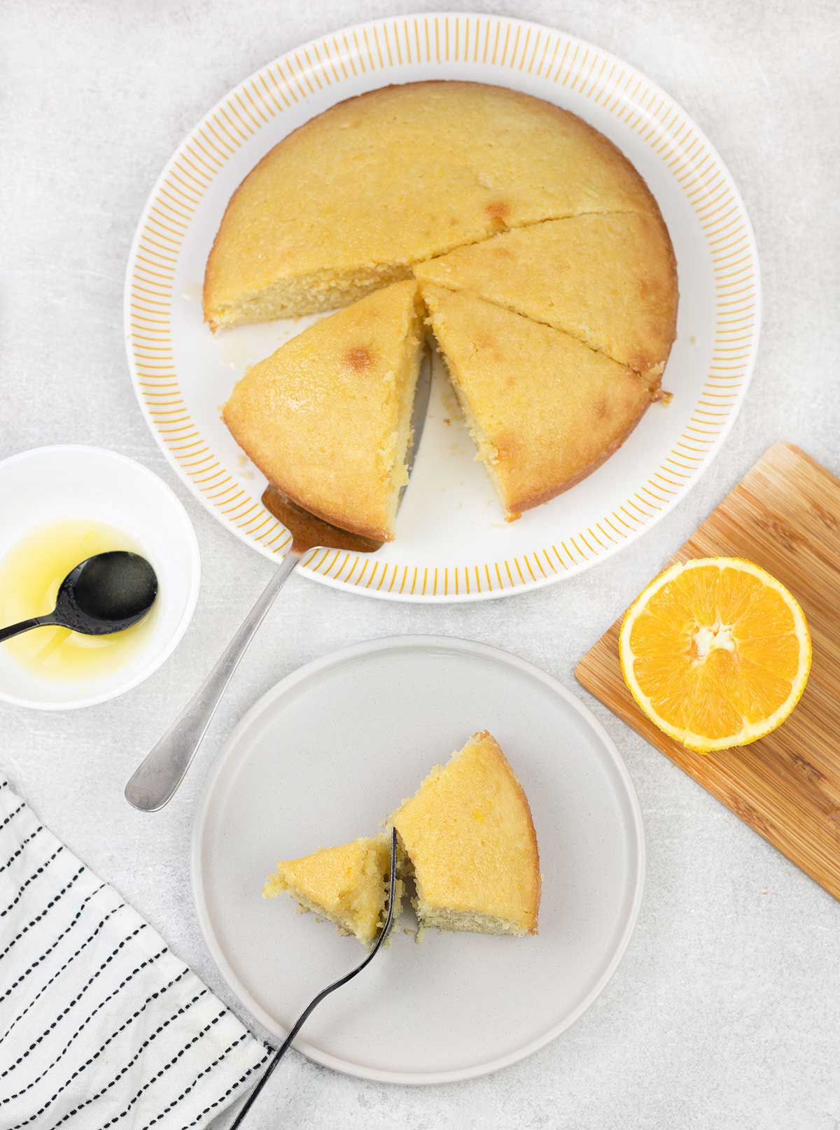 Orange Drizzle Cake and an orange and a cake slice in a plate.