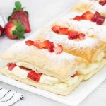 Strawberry Mille Feuille in a serving plate topped with fresh strawberries.