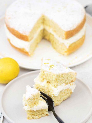 Eat a slice of the lemon victoria sponge and a fresh lemon is in the background.