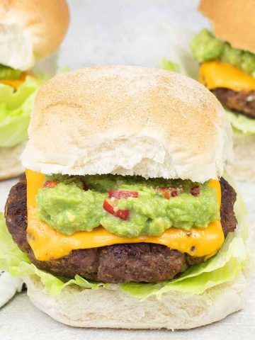 Mexican burgers topped with cheese and guacamole.