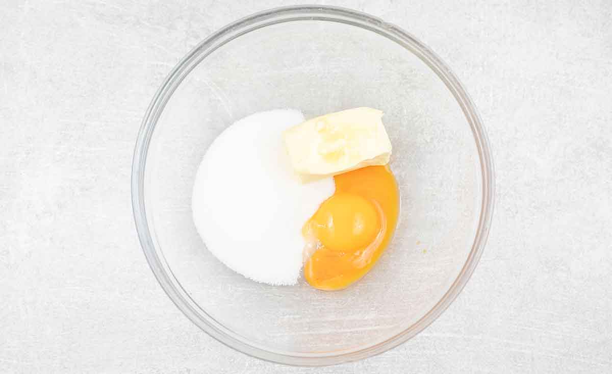 In a mixing bowl, mix sugar, butter, and egg yolks.