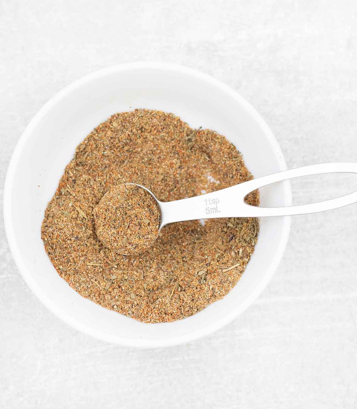 A teaspoon full of mediterranean spice blend.