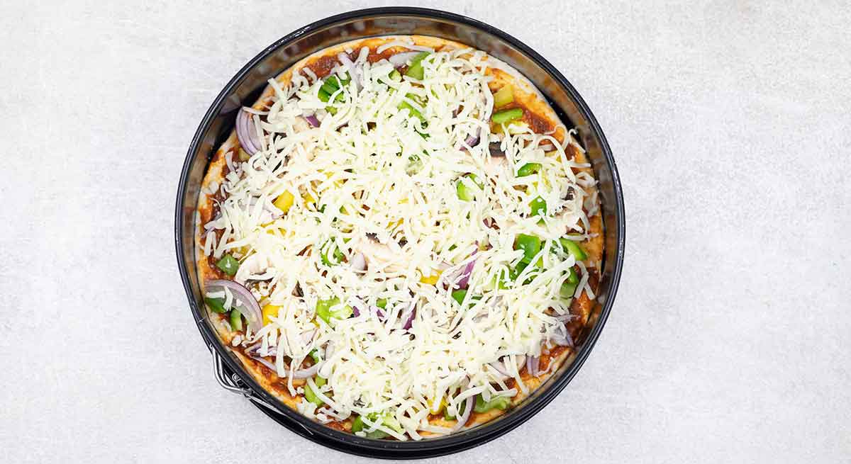 Finish the toppings with plenty of shredded Mozzarella cheese.