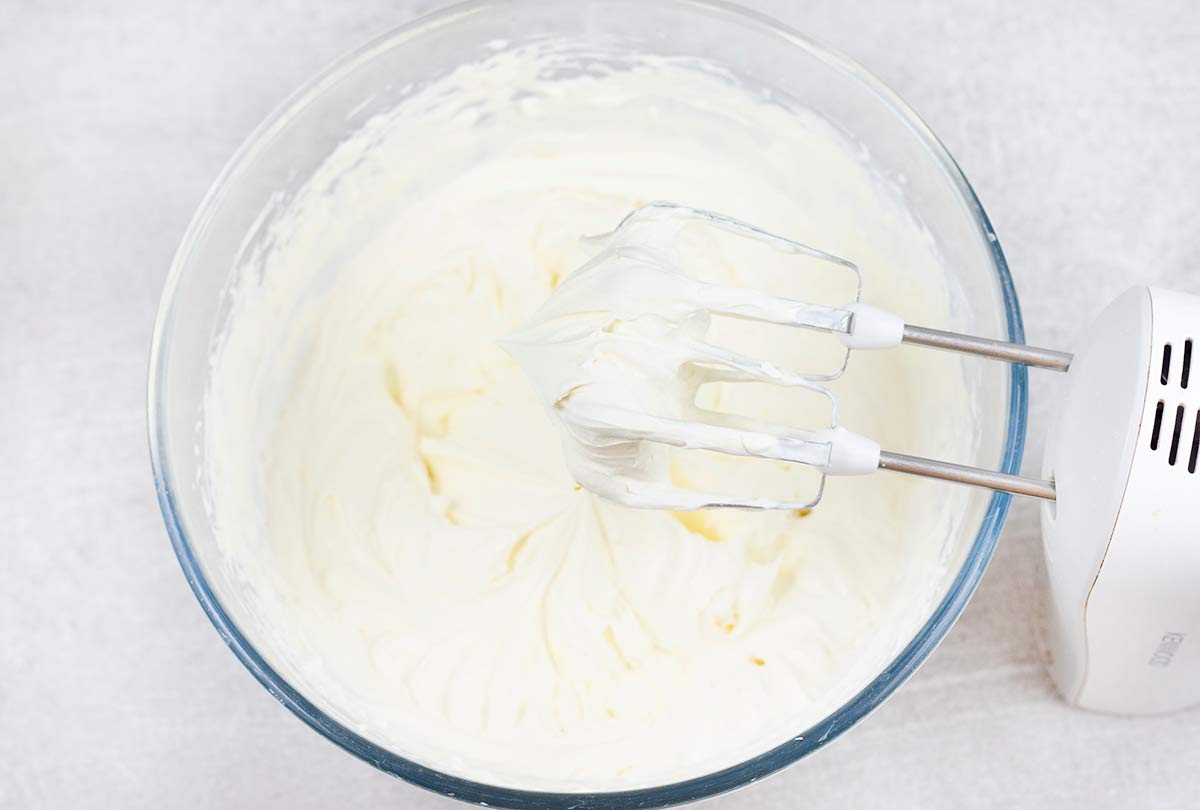 Whisk heavy cream and powdered sugar with an electric whisk until a stiff peak forms.