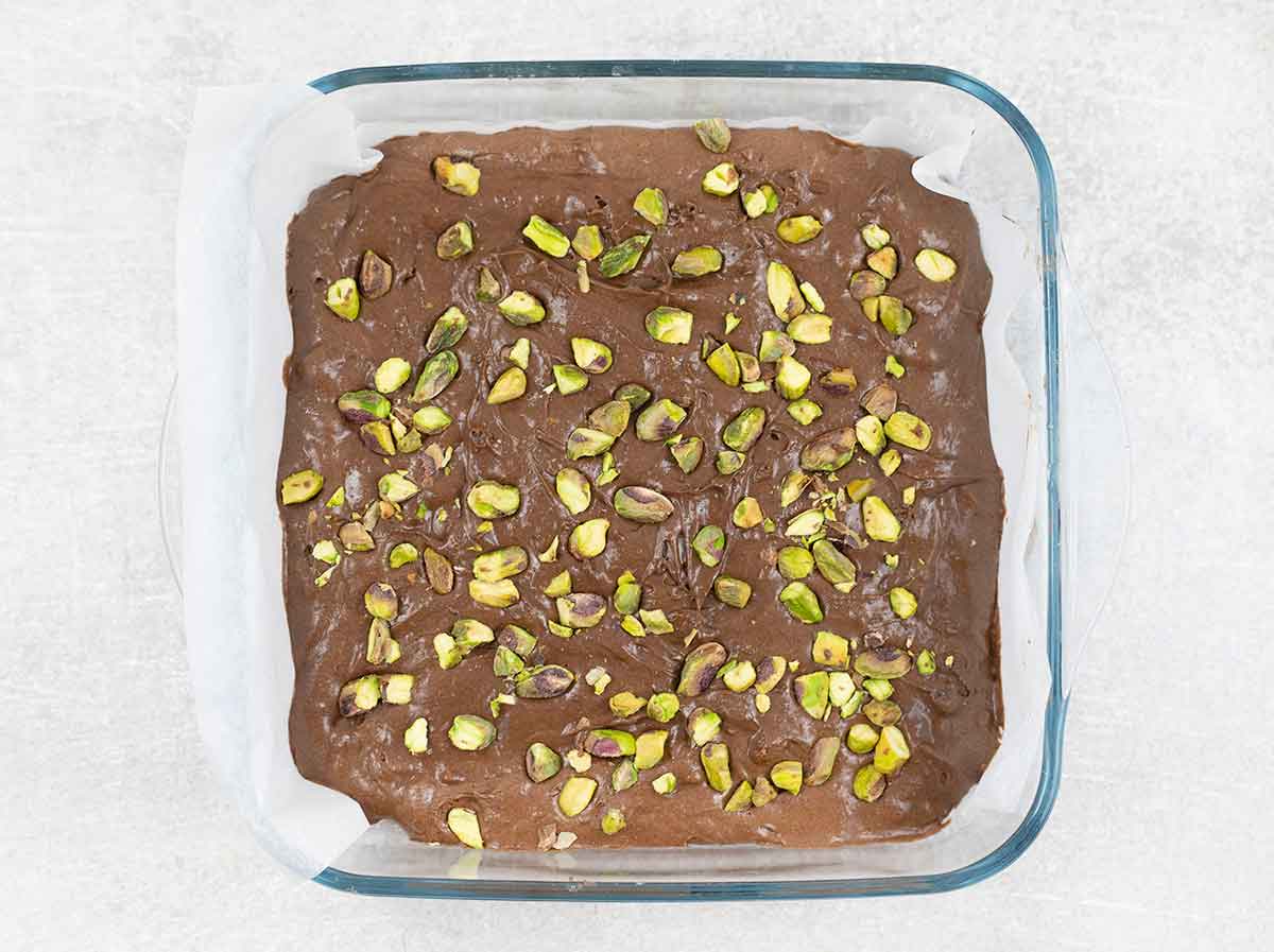 Pour the batter into the baking pan, sprinkle the remaining pistachios on top.