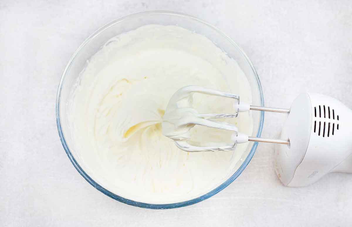 Whip heavy cream and powdered sugar with an electric mixer until stiff peak forms.