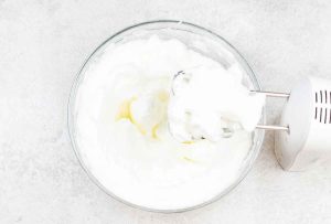 Beat the egg whites with the electric mixer until stiff peaks form.