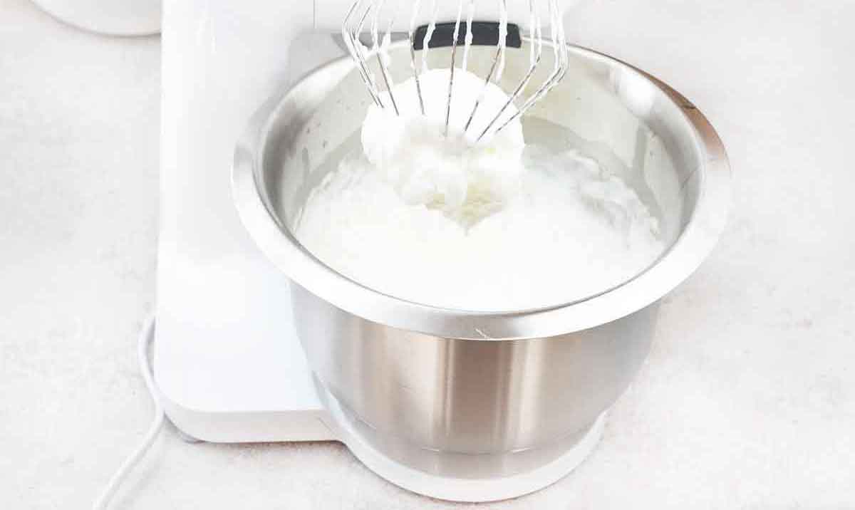 Whisk the egg whites in the second bowl with the electric whisk until a stiff peak forms.