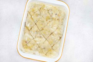 Brush the top with butter, cut the baklava tray diagonally using a sharp knife.