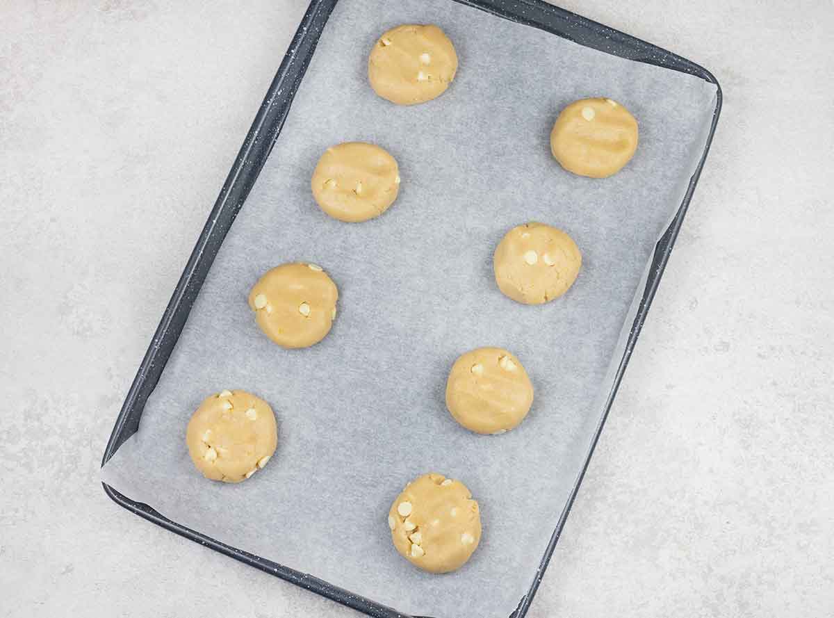 Place the cookies on the baking tray and slightly flatten them with your hand.