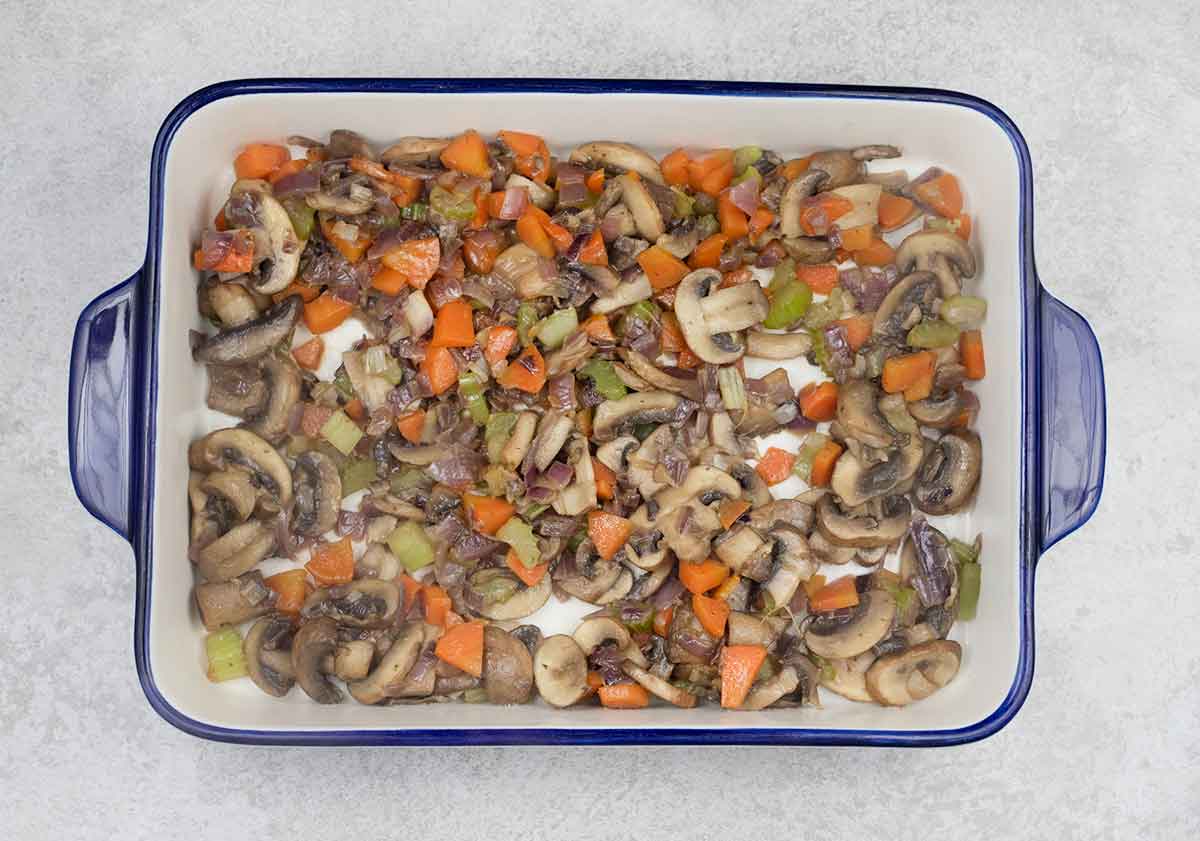 Add the softened mushroom and veggies to a 20x23 cm baking pan.