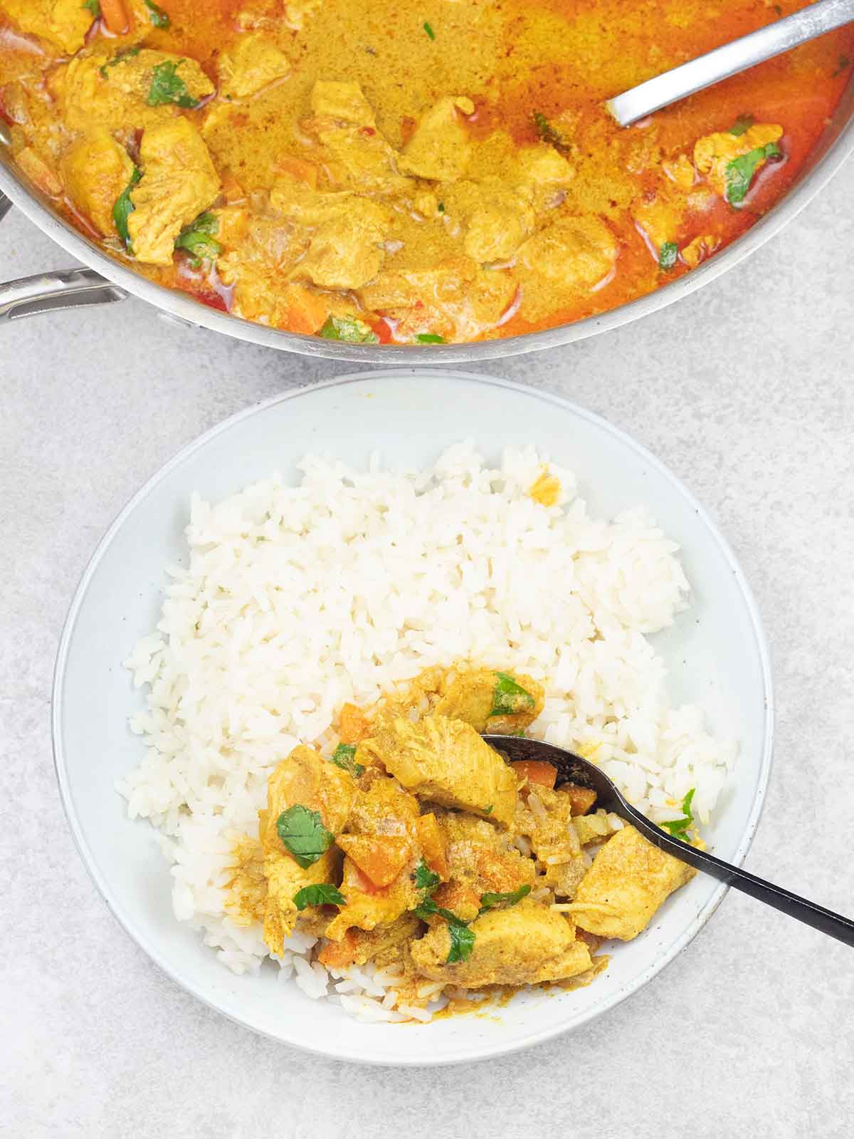 curry chicken on top of white rice.