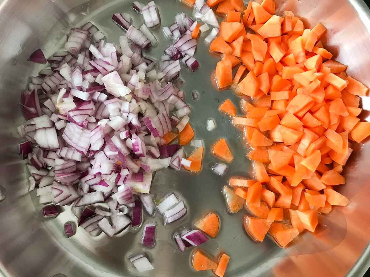 Heat the oil in a large frying pan over medium heat. Sauté carrot and onion.