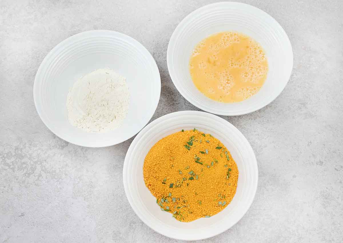 Prepare 3 bowls; in the first one, the eggs; in the second one, the flour; and in the third one, the breadcrumbs and rosemary.