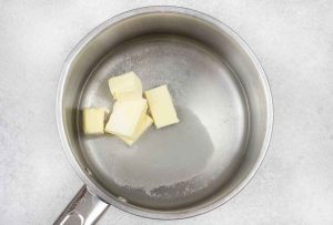 In a saucepan, add butter, sugar and water over low.