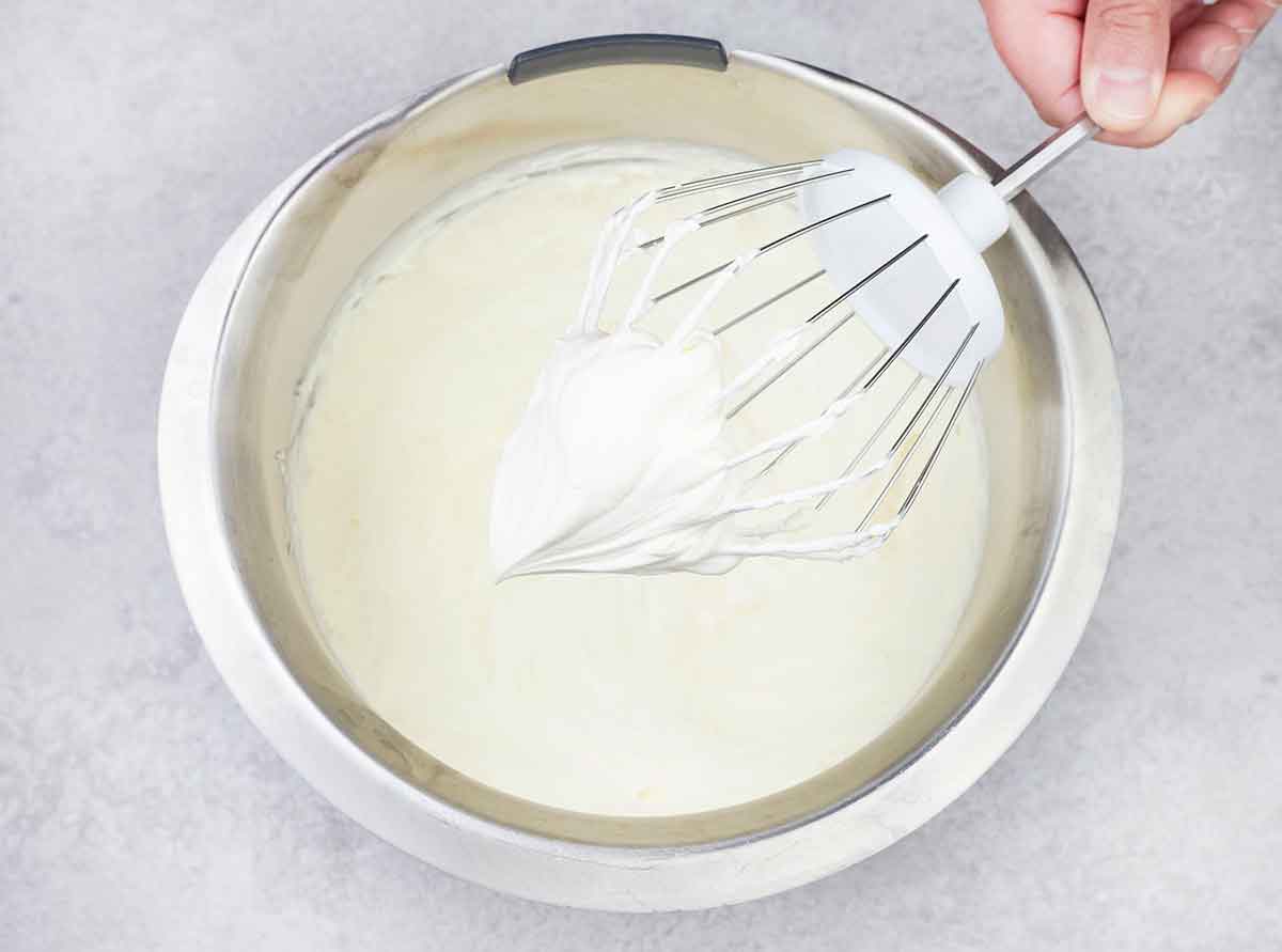 In a stand mixer bowl, add the cold heavy cream and powdered sugar and whip until a stiff peak forms.