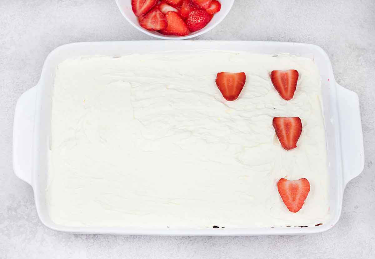 spread the whipped cream on top of the cake and decorate with strawberry slices.