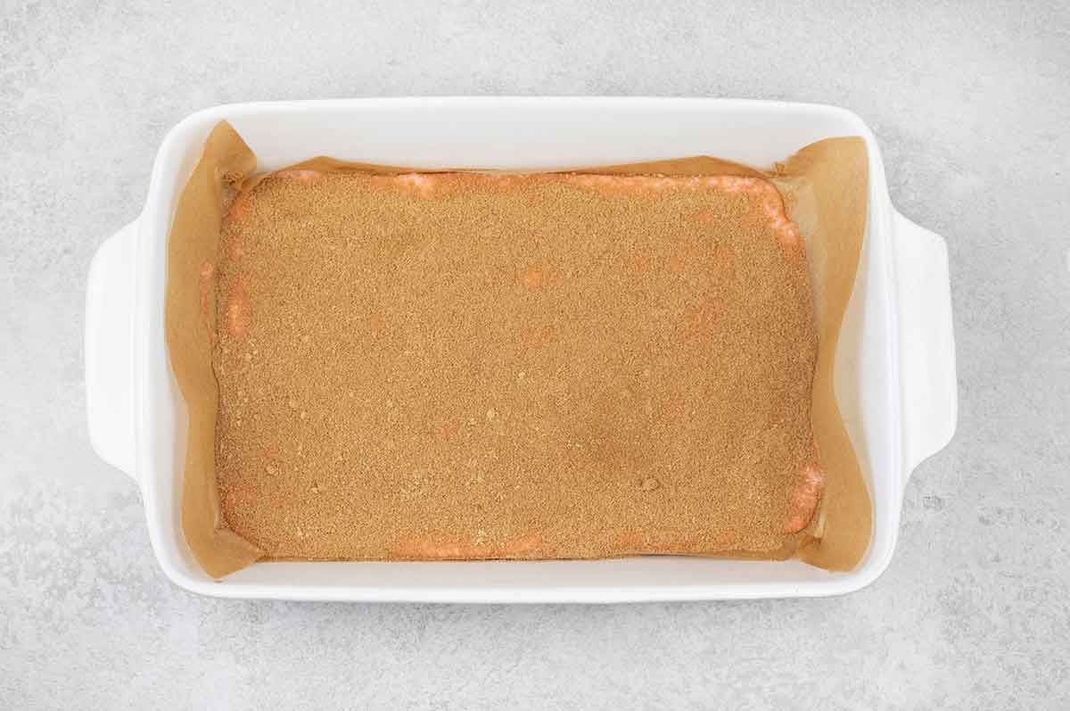 half of the cake batter in a baking pan toped with cinnamon sugar mixture.