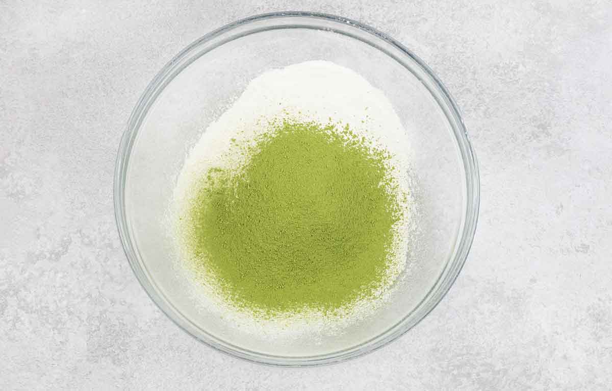 Sifted flour and matcha powder in a mixing bowl.