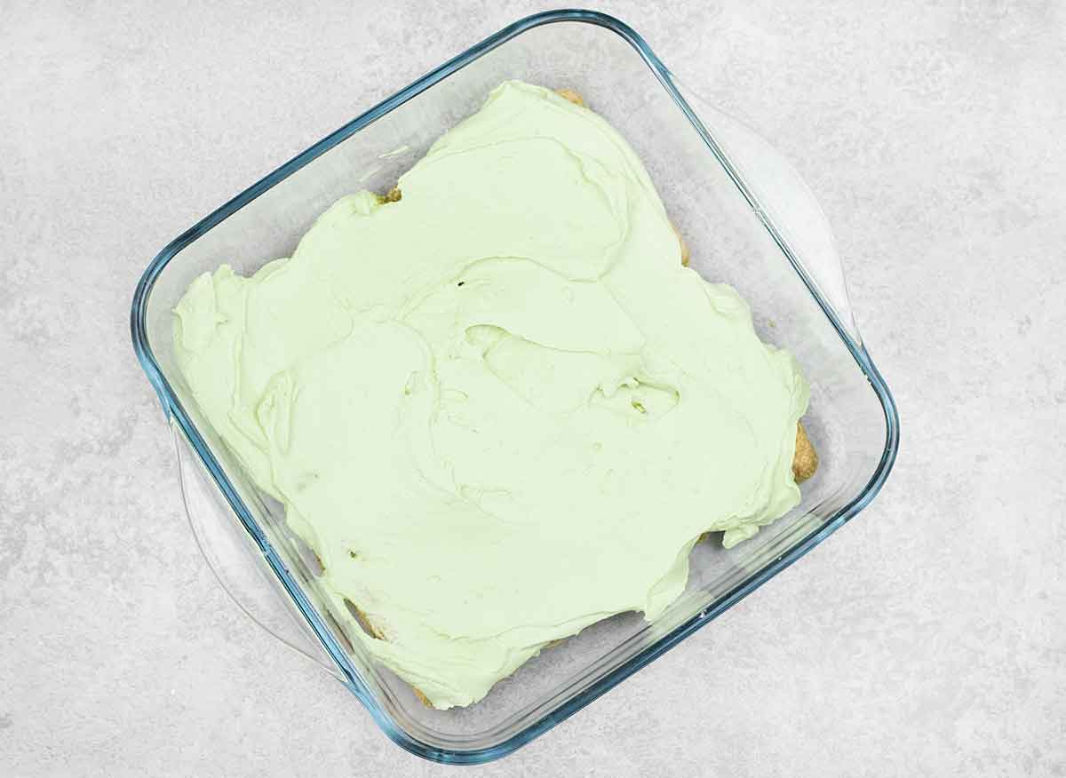 A thick layer of the mascarpone mixture spread over the ladyfingers.