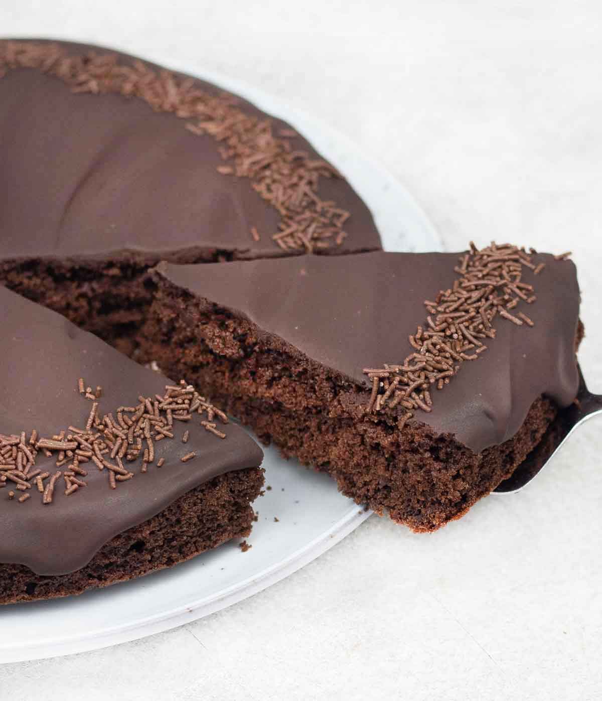 Slice of chocolate cake with rich chocolate ganache topping.