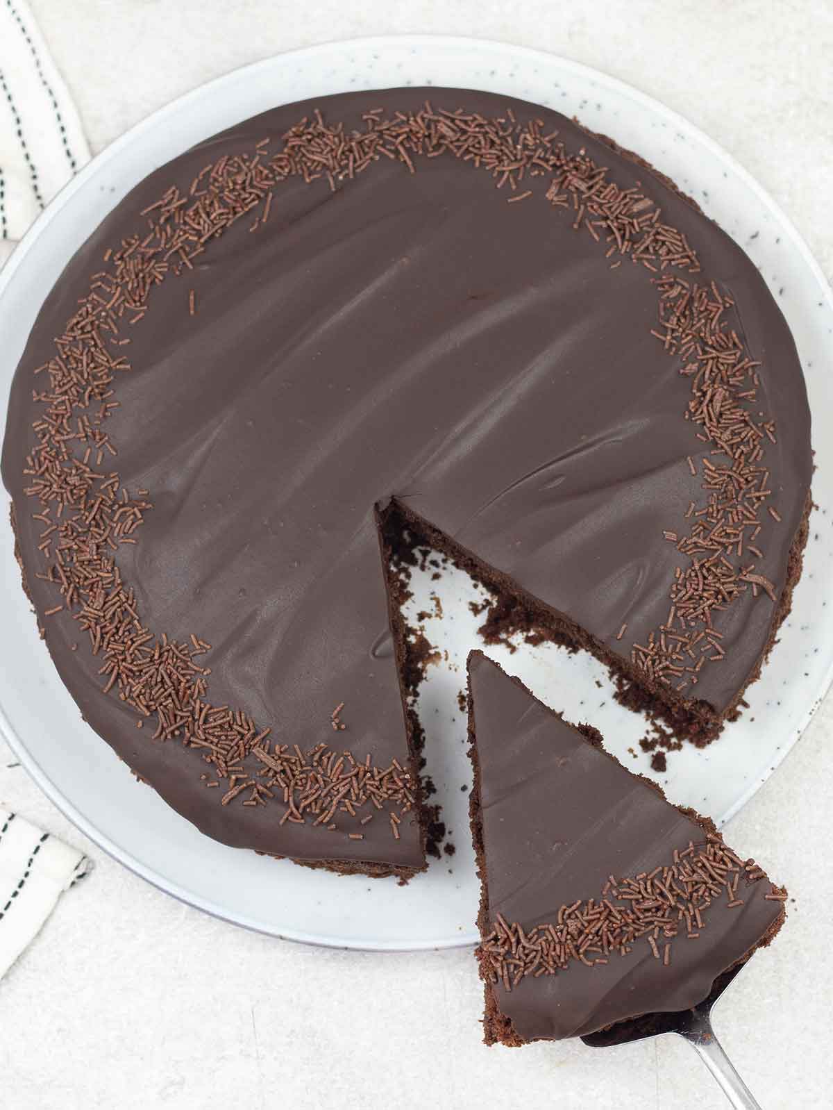 one layer chocolate cake decorated with chocolate ganache and chocolate sprinkles.
